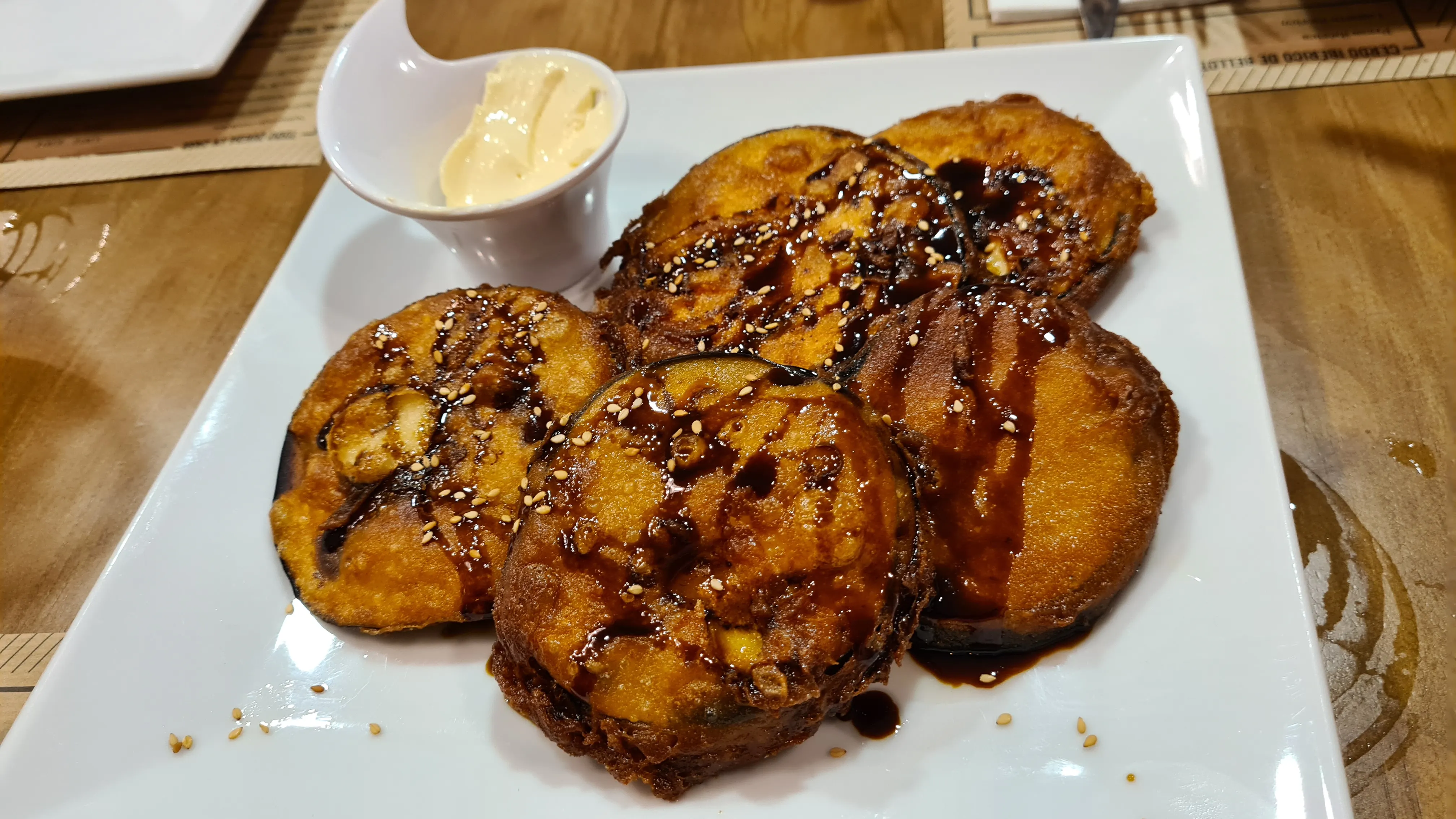 Patatas asadas con queso fundido y salsa, servidas en A Fuego Brasería